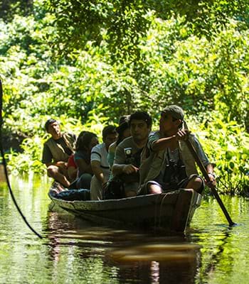 Turistas recorriendo riachuelos en un bote por el Parque Nacional del Manu
